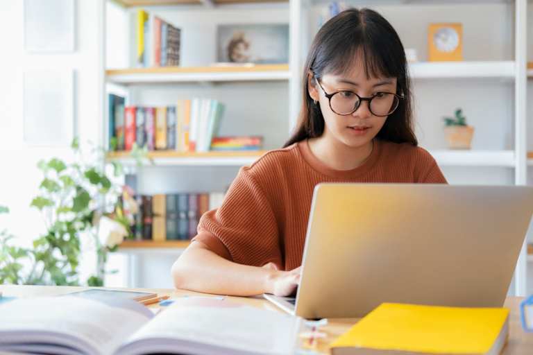 Young collage student using computer and mobile device studying
