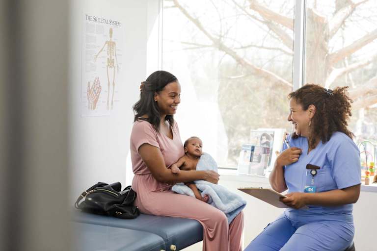 Nurse helping mother with young baby