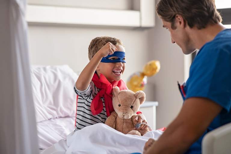 Pediatric nurse helping a kid dressed as a superhero
