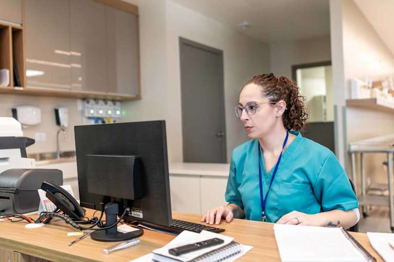 Medical coder at computer in hospital