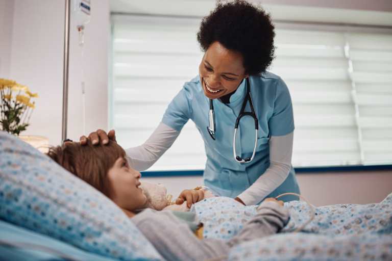 Nurse touching a child patient's head and smiling