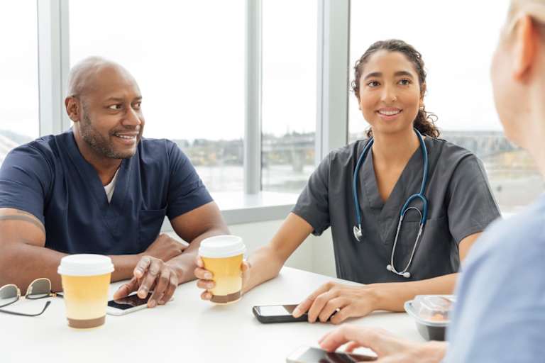 Nurses talking to each other at a cafe table