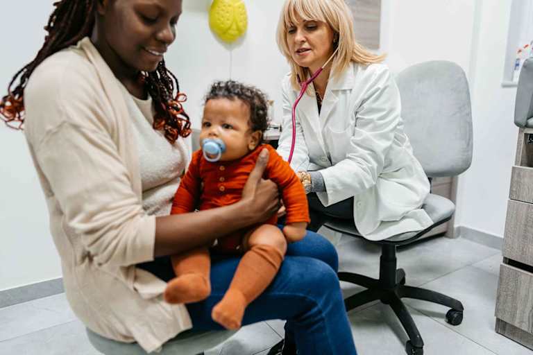 Pediatric nurse listening to baby breathing