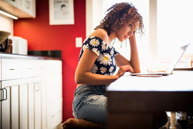 Woman studying on laptop in kitchen