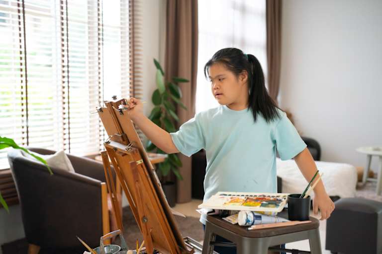 Young girl painting on easel