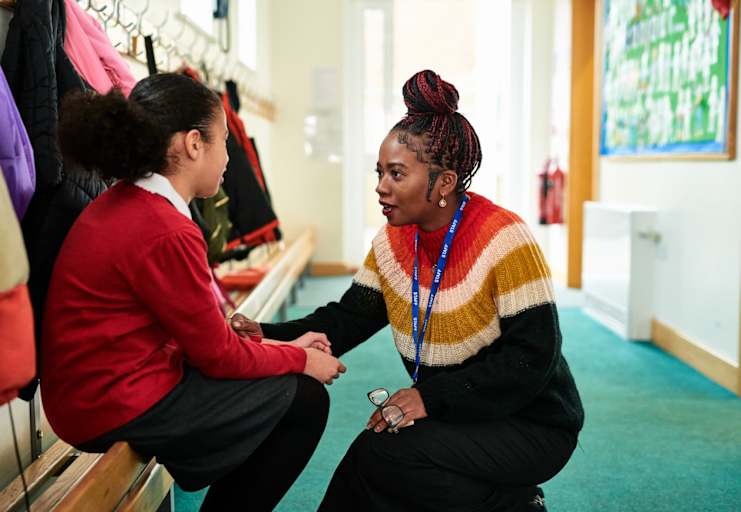 School psychologist talking to child in classroom