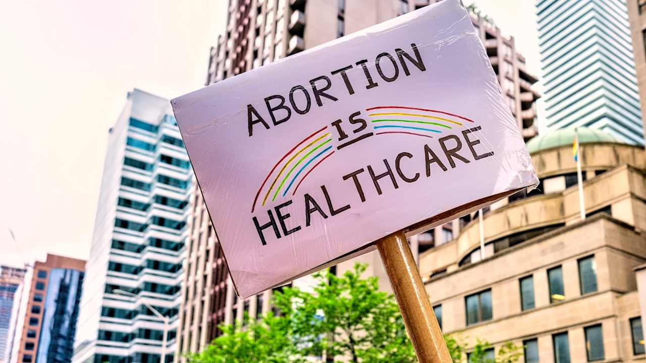 Low angle view of sign in Pride Parade. The sign says "Abortion is Healthcare"