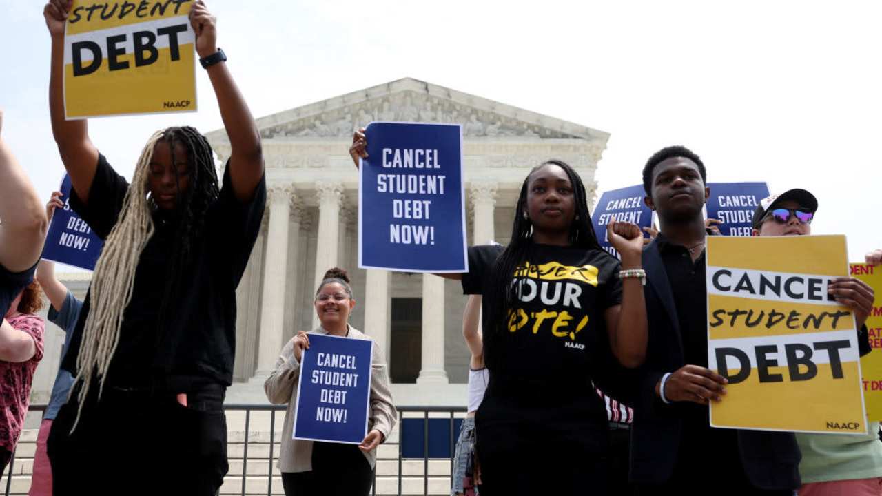 Activists holding signs that read "cancel student debt" outside of the US Supreme Court Building