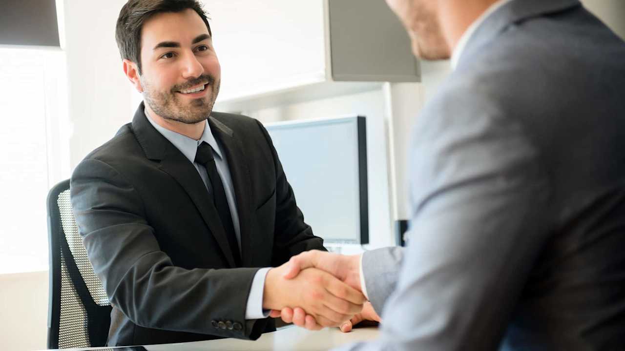 Two business men shaking hands in an office.