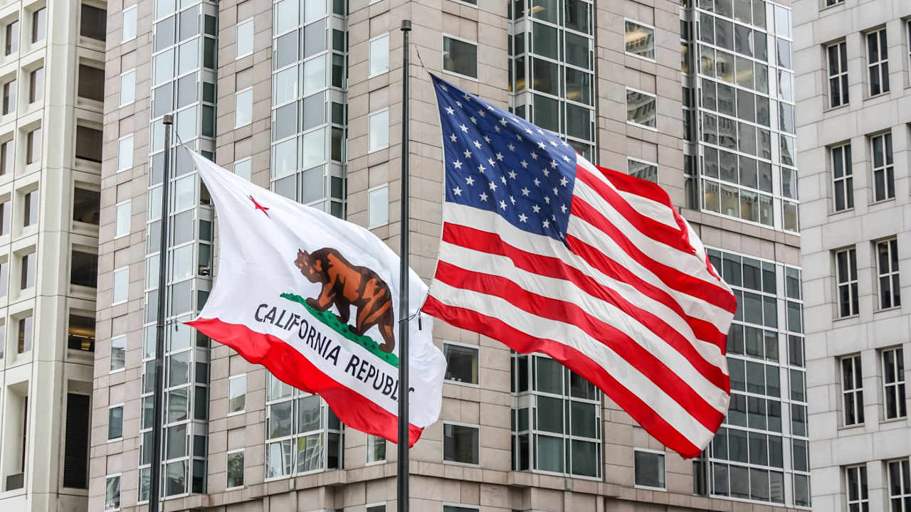California and American flags waving in front of a building
