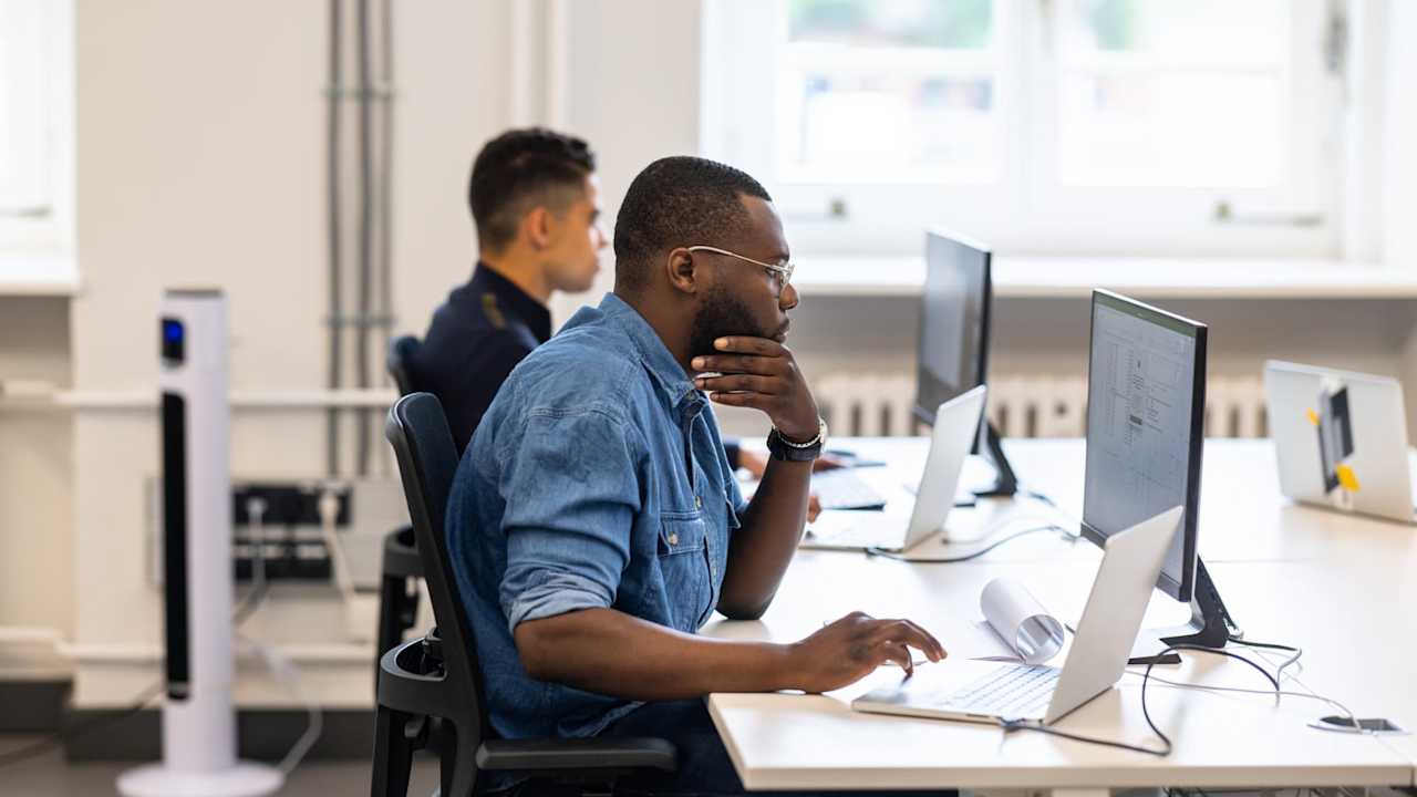 Computer programmers working on desktops