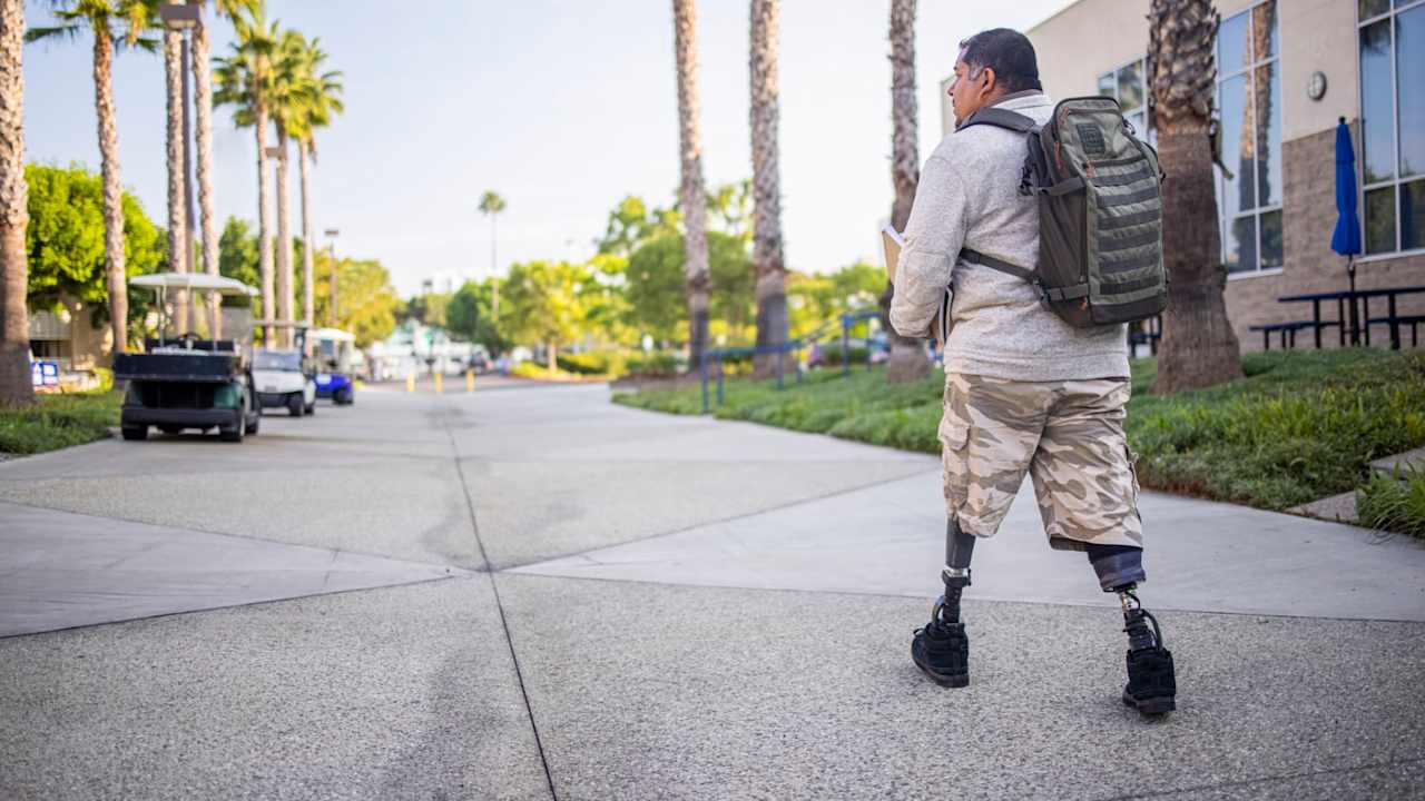 A young Hispanic American Veteran college student going to class. He is a double amputee.
