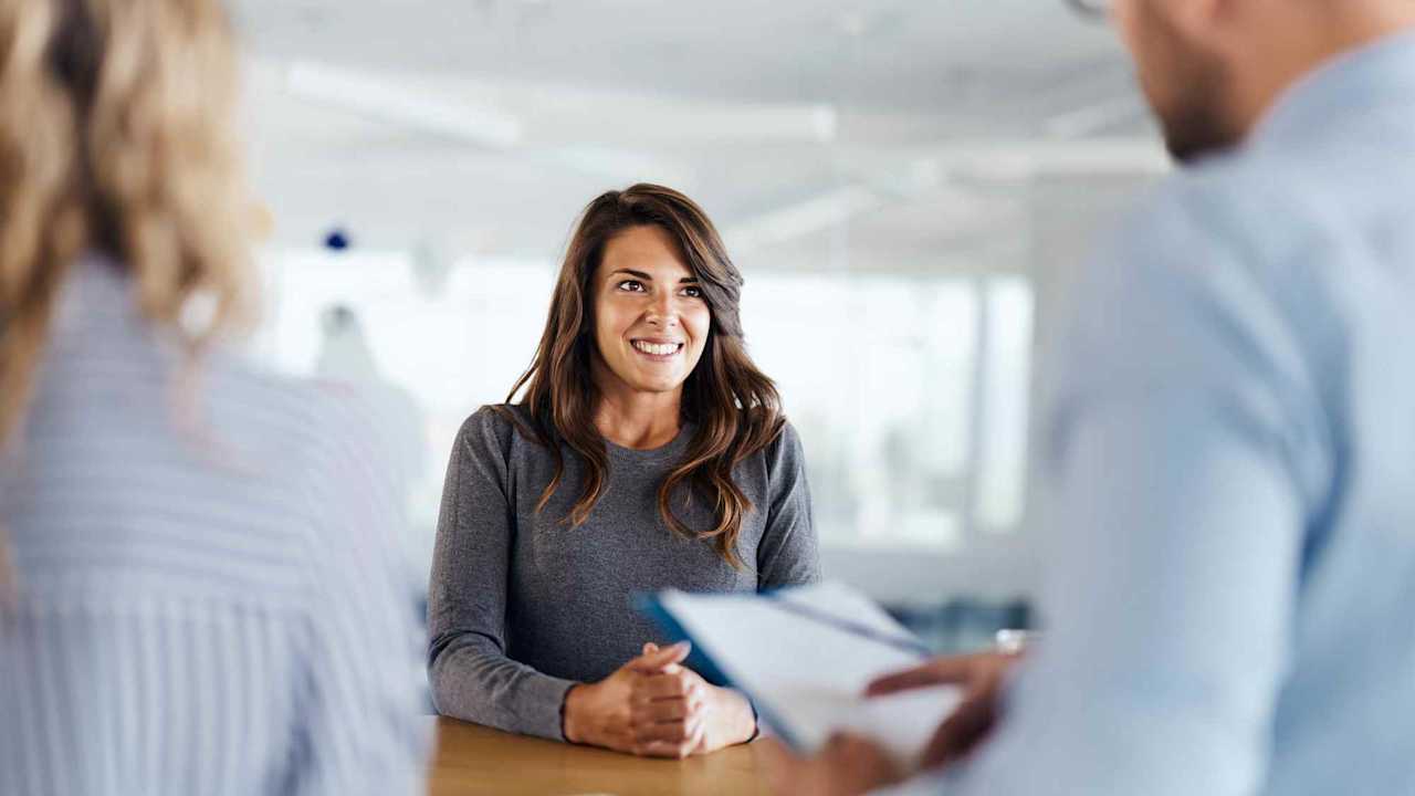 Young female candidate talking to human resource team during a job interview in the office.