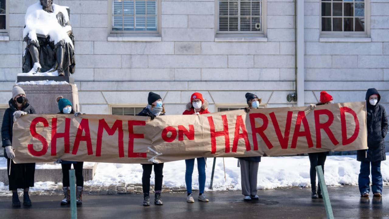 Demonstrators hold a banner during a 'No Justice Walkout' protest at Harvard University in Cambridge, Massachusetts, U.S., on Monday, Feb. 14, 2022. Harvard allowed a star professors sexual abuse of female students to continue unchecked for decades, contributing to a culture of harassment in its Anthropology Department, a new lawsuit alleges. Harvard University disputes the allegations of the lawsuit.