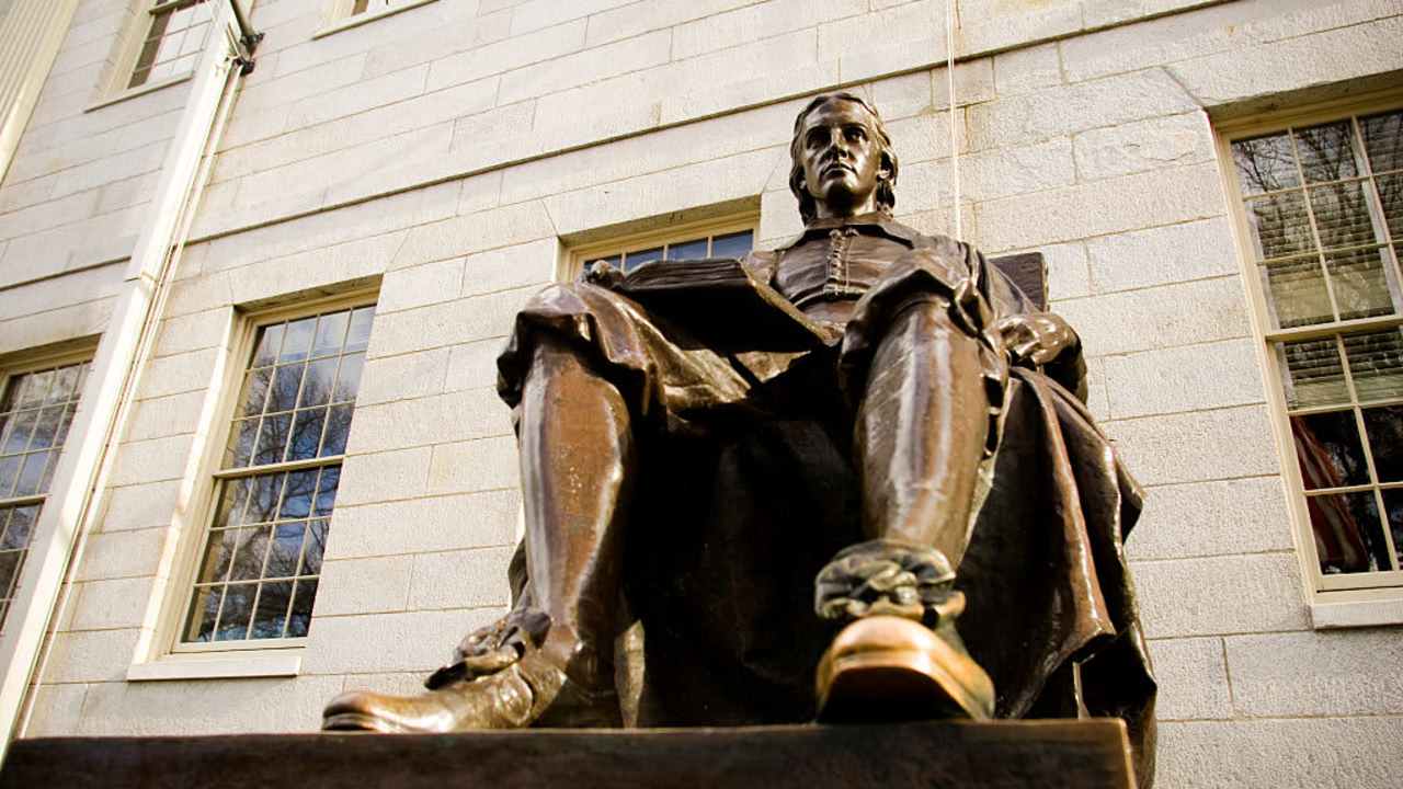 The John Harvard statue on the Harvard University campus in Cambridge. Massachusetts.