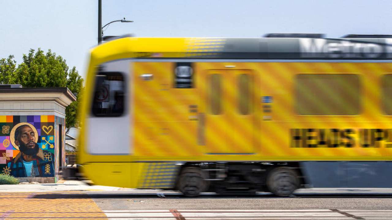 LOS ANGELES, CA -AUGUST 22, 2022:A metro train, traveling on the new K Line, goes past a mural of the late rapper Nipsey Hussle, located on Crenshaw Blvd.at Slauson Ave. in Los Angeles, during a test run. Metros K Line (Crenshaw/LAX Transit Project) will extend light rail from the existing Metro E Line (Expo) at Crenshaw and Exposition Boulevards to the Metro C Line. While the rail line includes 8 new stations, only 7 will be open in the fall of 2022. The train will travel 8.5 miles and will serve the cities of Los Angeles, Inglewood, and El Segundo and portions of unincorporated Los Angeles County. (Mel Melcon / Los Angeles Times via Getty Images)
