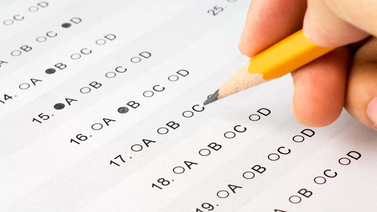 Hand completing a multiple choice exam. The answer form was created by me and is not copyrighted.