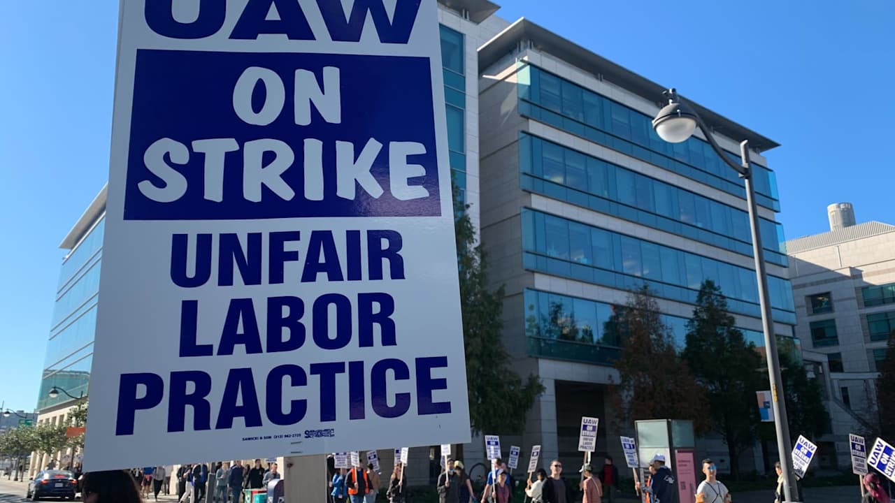 Academic workers hold signs and march at a strike in front of the University of California San Francisco campus administrative office to demand higher wages and more benefits for international students and working parents.