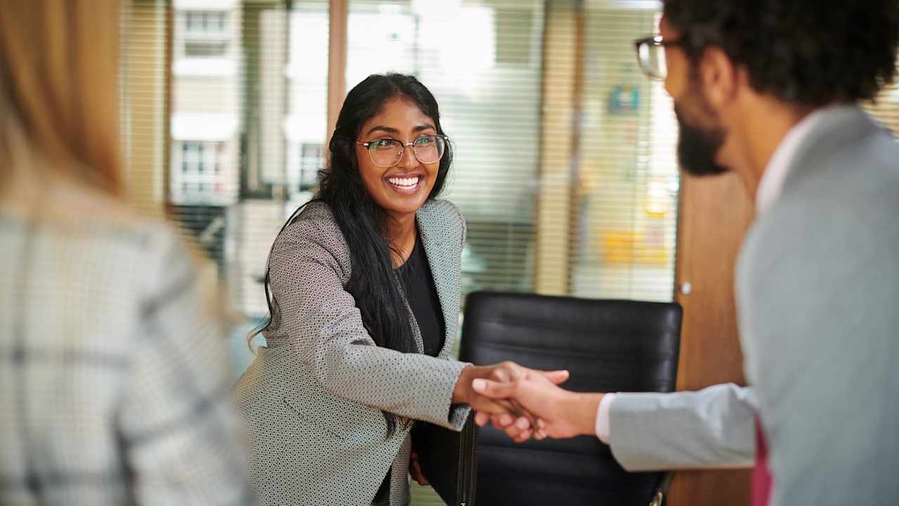 Young business professional shakes hands after a job interview