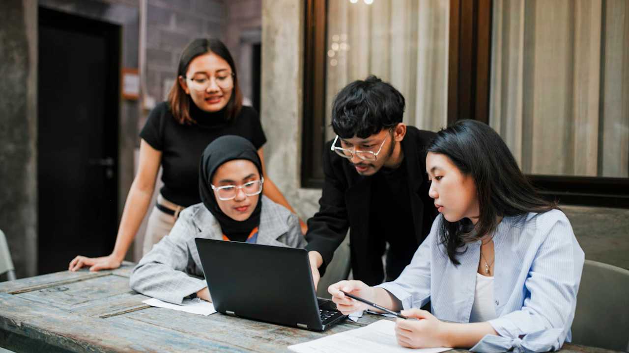 Asian students in the university are presenting to their friends.
