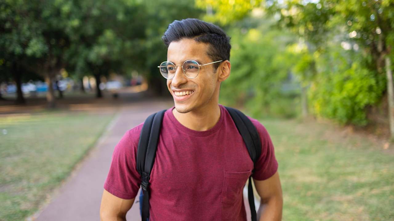 Portrait of a handsome man laughing and toothy smiling. He is looking away