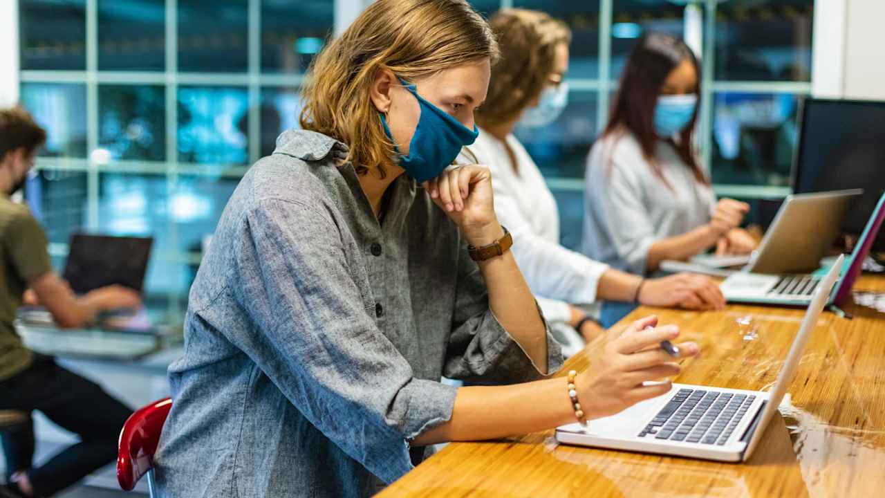 College Students Wearing Face Masks Working Together in a Computer Lab