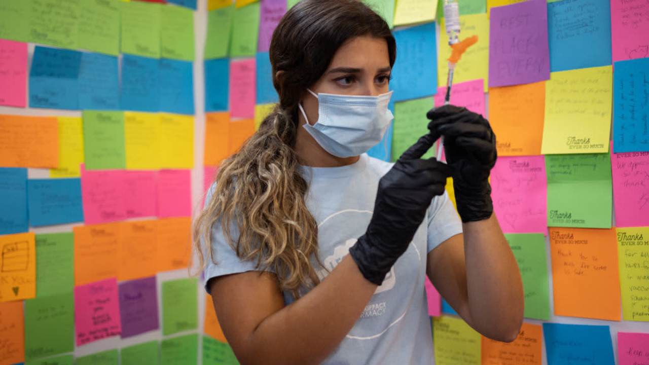 A healthcare worker prepares a dose of a Covid-19 booster vaccine at a pharmacy in Schwenksville, Pennsylvania.