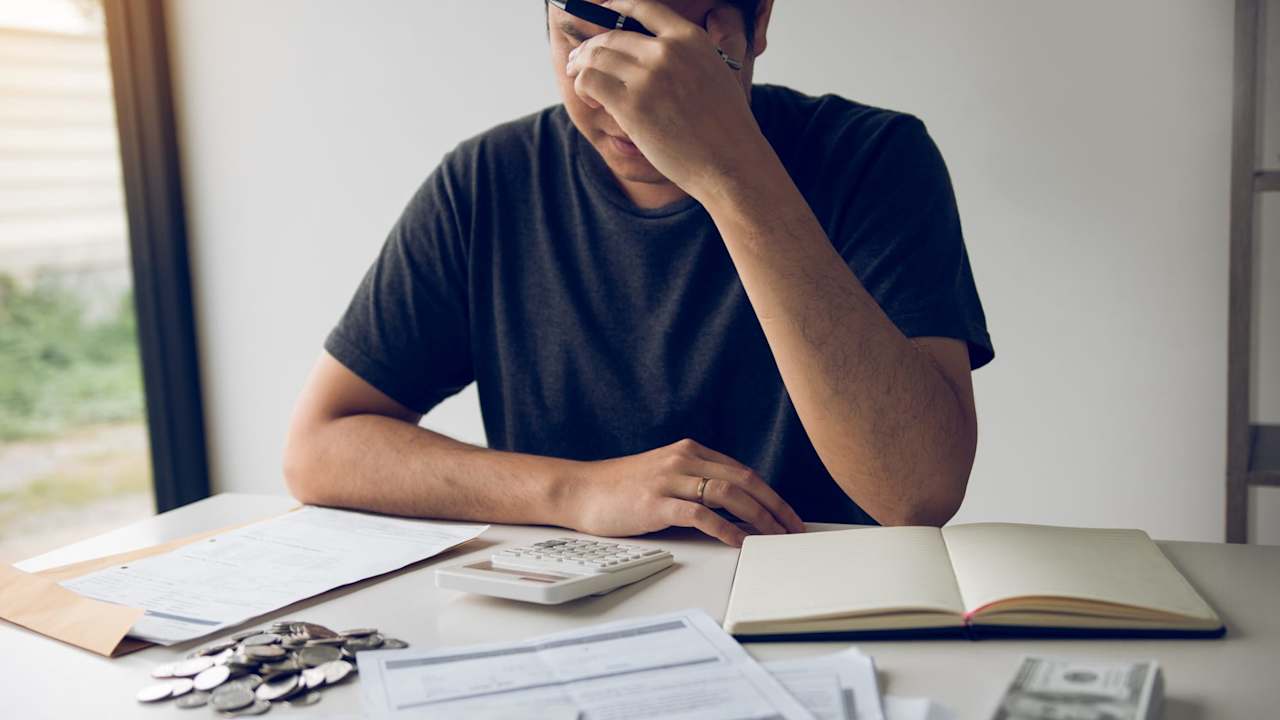Man With Head In Hands Calculating Bills