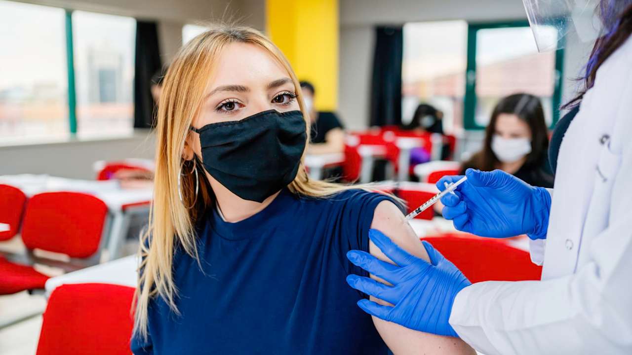 Nurse gives students a vaccination in school during coronavirus pandemic