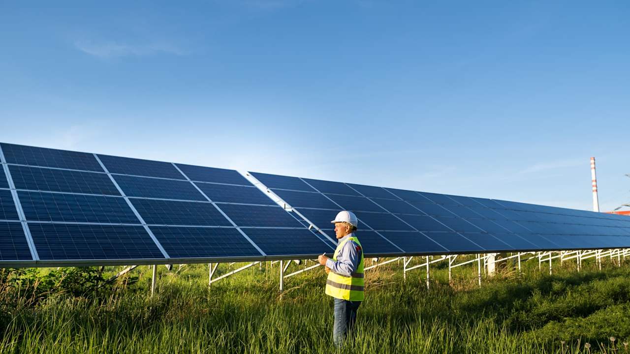 Solar engineer working with digital tablet at renewable energy farm