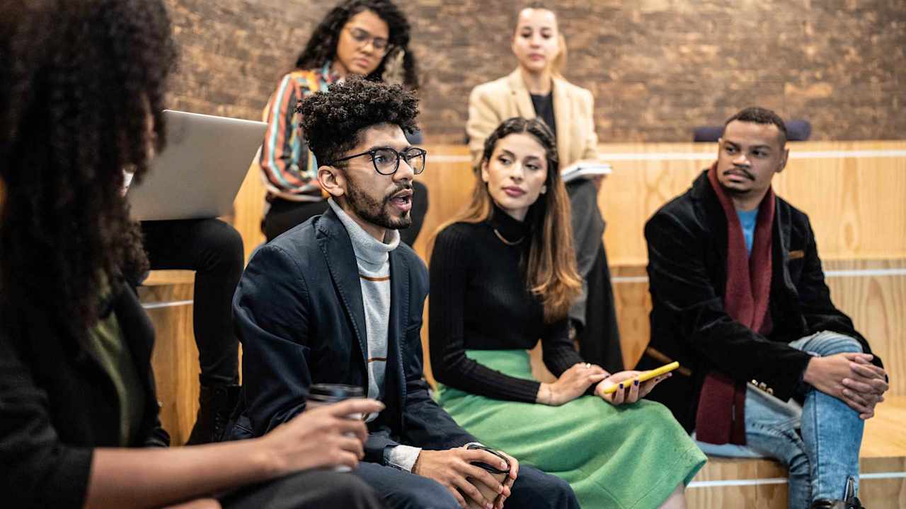 Diverse group of college students having a discussion in a seminar class on campus.