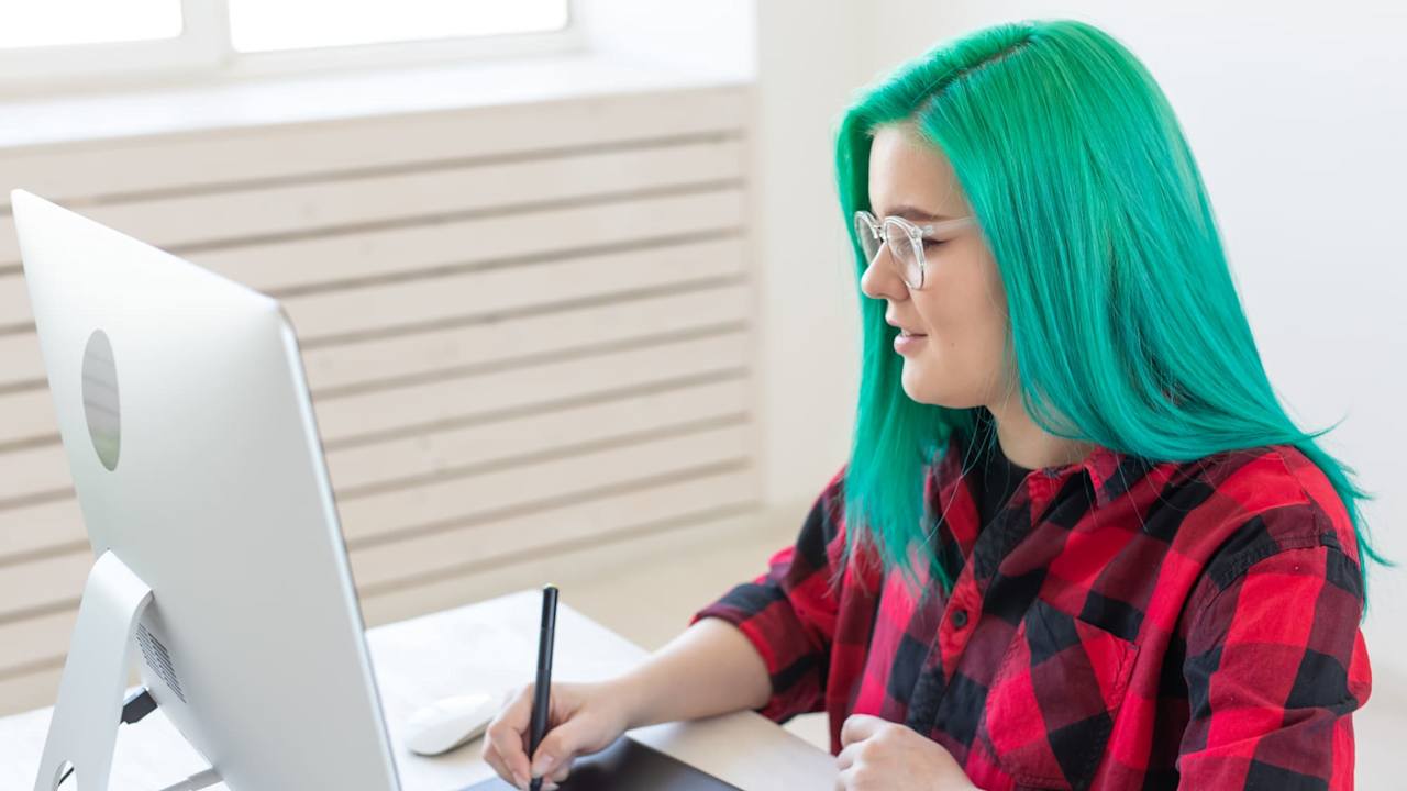 Woman drawing on a digital tablet using a desktop computer