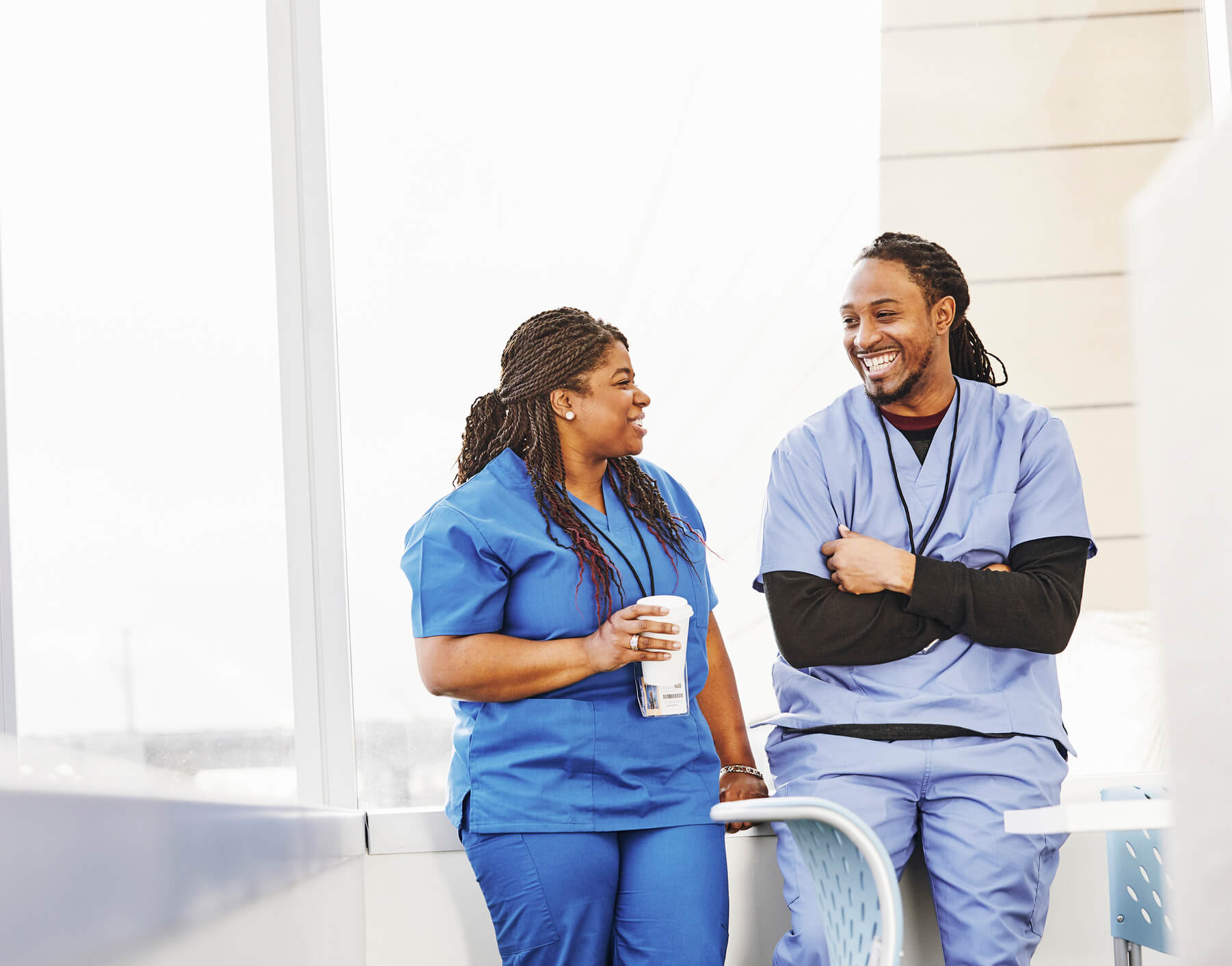 Male and female nurse talking in a hospital lounge