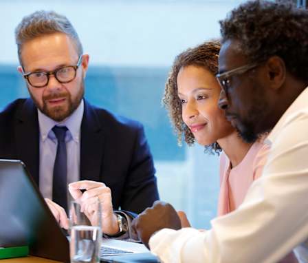 Three people working on a laptop
