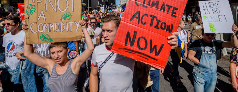 Photo of participants marching to Battery Park holding signs that say things related to climate change