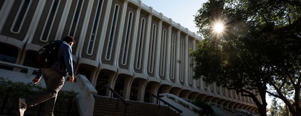 A student walks past Langson Library on the University of California campus in Irvine, CA.