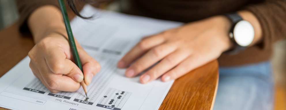 High school student sitting at a classroom desk taking the ACT examination.