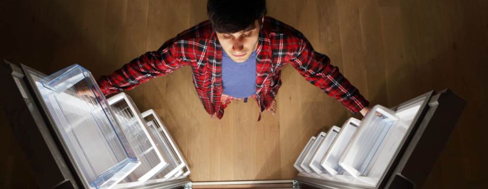 Man looking into empty fridge at night