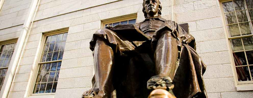 The John Harvard statue on the Harvard University campus in Cambridge. Massachusetts.