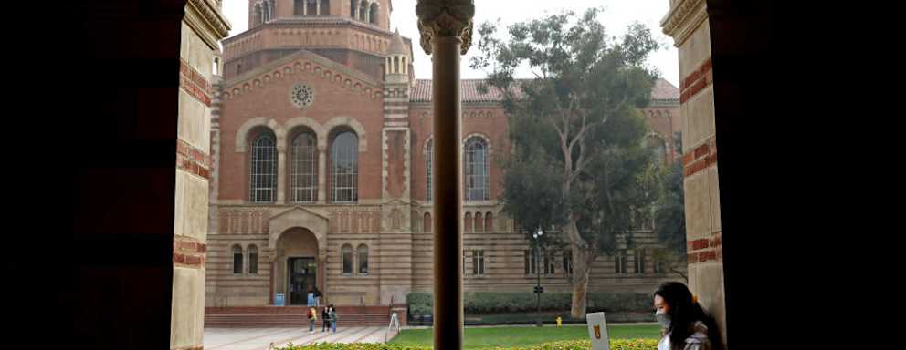 A student studying on the UCLA campus grounds in Los Angeles, California.
