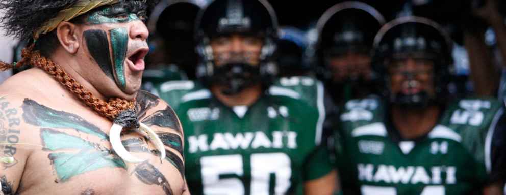 the University of Hawaii Mascot cheers as the University of Hawaii Warriors prepare to take the field in their season opener