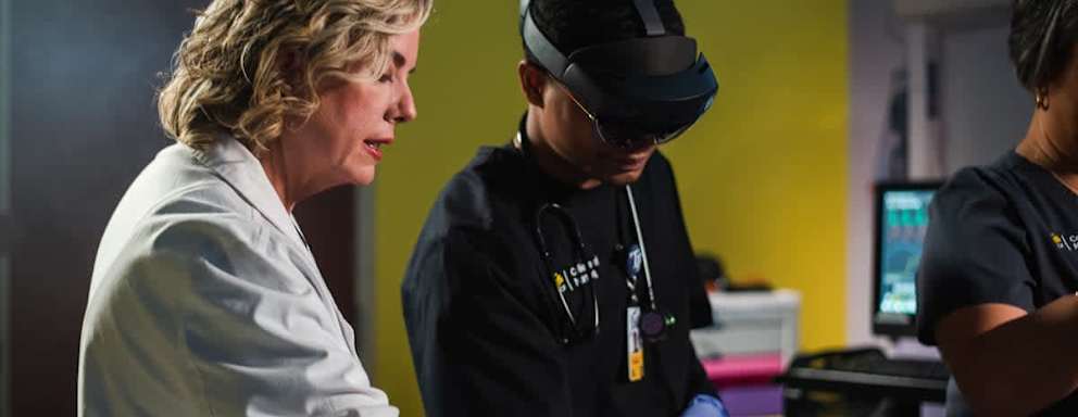 A student and a professor working with nursing simulation tech in a lab on campus