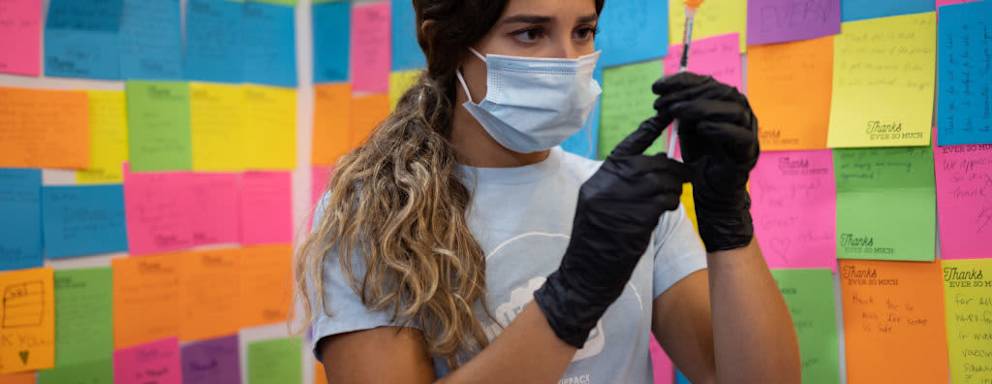 A healthcare worker prepares a dose of a Covid-19 booster vaccine at a pharmacy in Schwenksville, Pennsylvania.