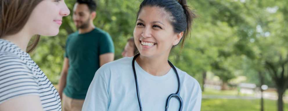 Community nurse outdoors with patient