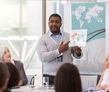 A public health speaker presenting statistics using visual aids at a global heath conference.