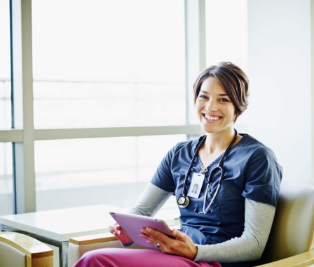 Nurse sitting in lounge with tablet