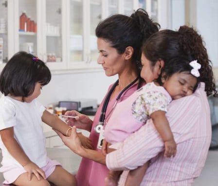 Mother watching doctor giving daughter injection