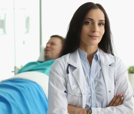 Nurse posing with patient in background