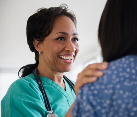 Smiling nurse comforting patient