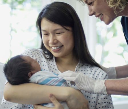 Nurse attending mother and newborn